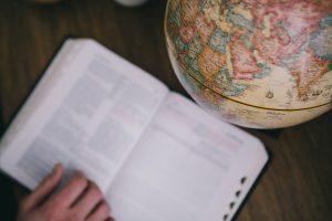 A photo of a bible next to an old globe